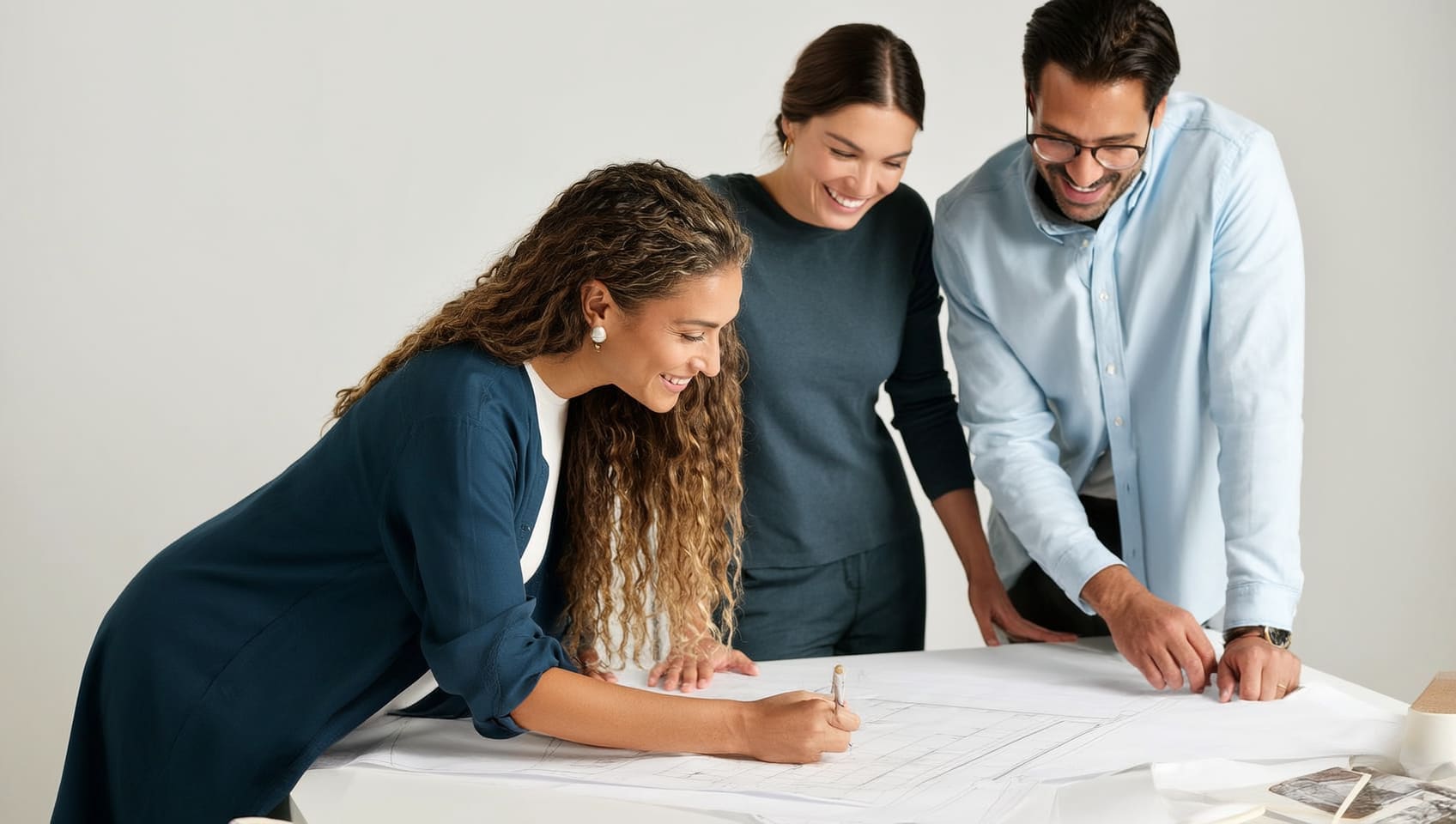 JULY design team refining floor plans together over a drafting table